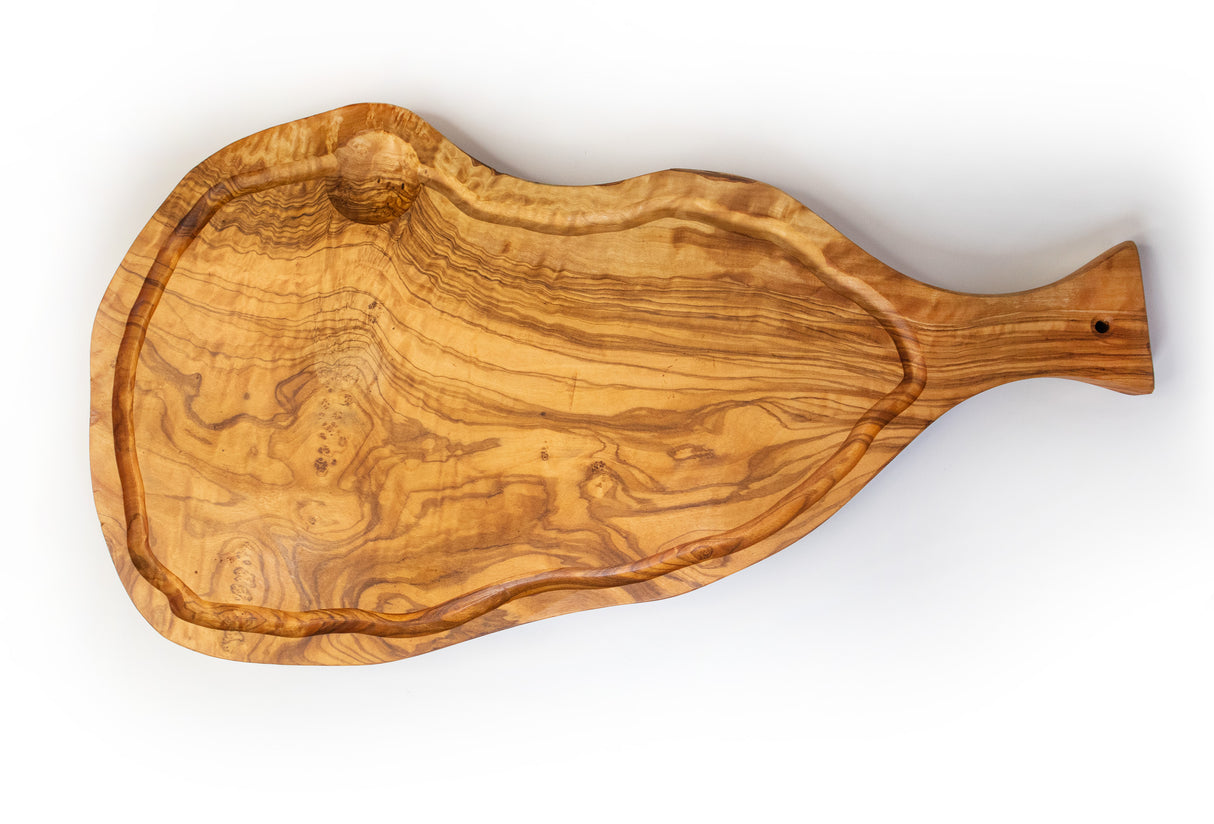 A rustic olive wood cutting board with a handle and juice groove, isolated on a white background.