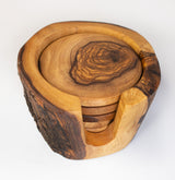 A set of six rustic olive wood coasters with a holder, featuring natural grain patterns and an organic shape.