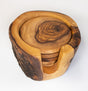 A set of six rustic olive wood coasters with a holder, featuring natural grain patterns and an organic shape.